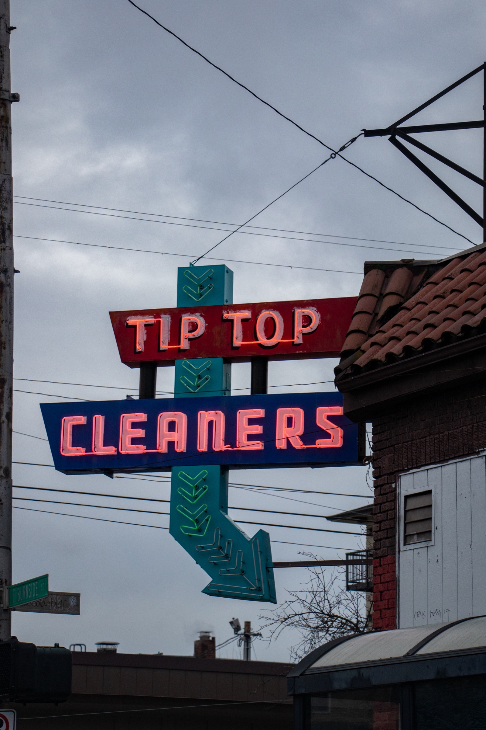 Vintage Tip Top Cleaners neon sign against a cloudy sky